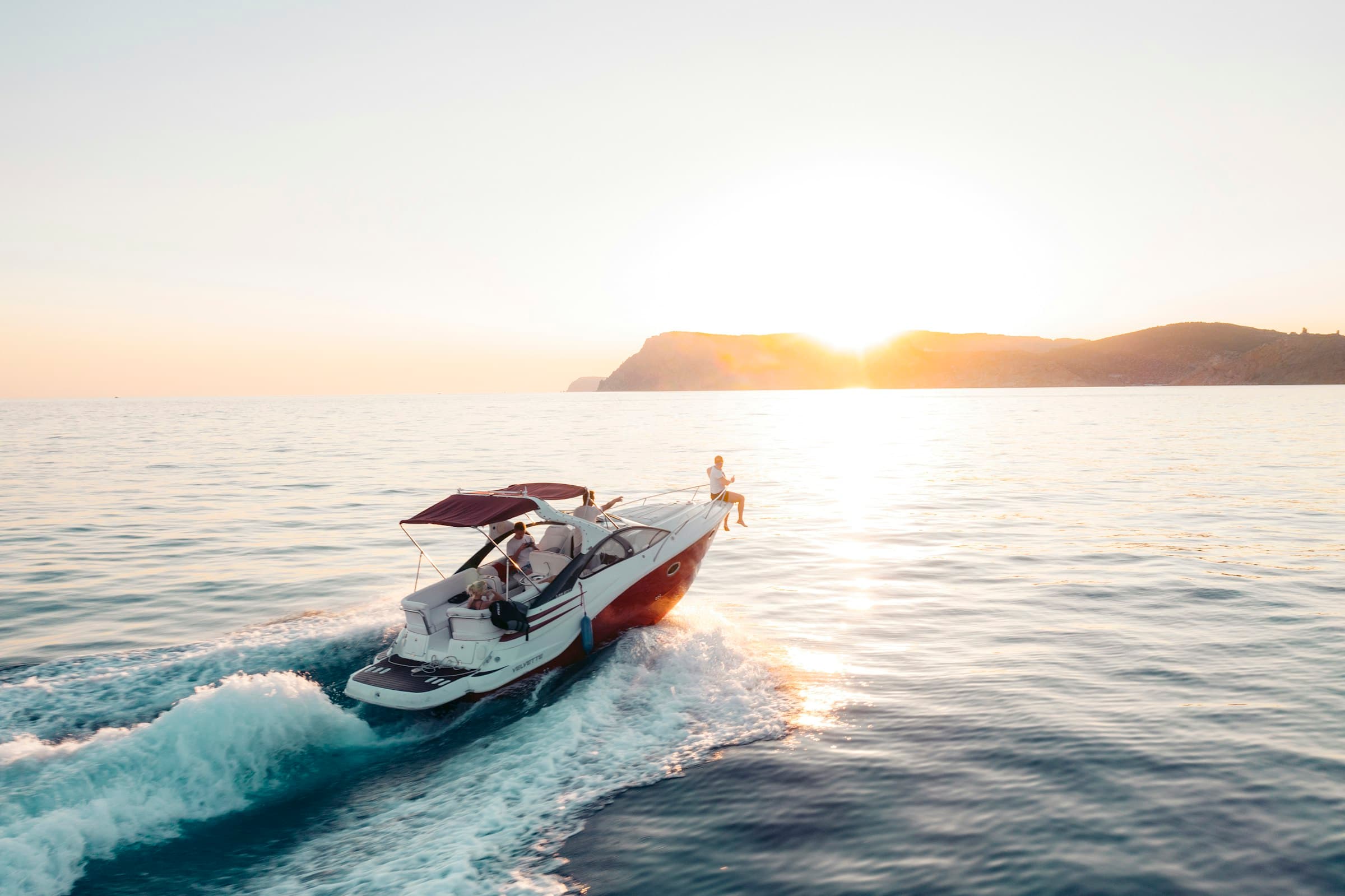 A boat cruising at golden hour with guests aboard